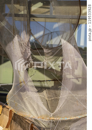 Worn fishing net hanging in sun, vintage Worn fishing net hanging in sun, vintage 119533928