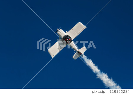 Stunt aerobatic plane performing stunts in air Stunt aerobatic plane performing stunts in air 119535284