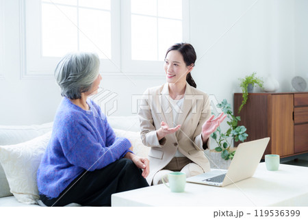 訪問営業の話を聞く中高年の女性 119536399