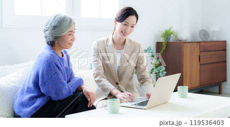 訪問営業の話を聞く中高年の女性 119536403