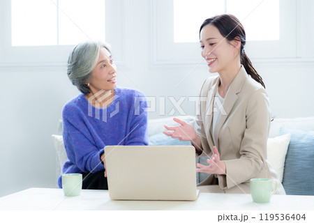 訪問営業の話を聞く中高年の女性 119536404