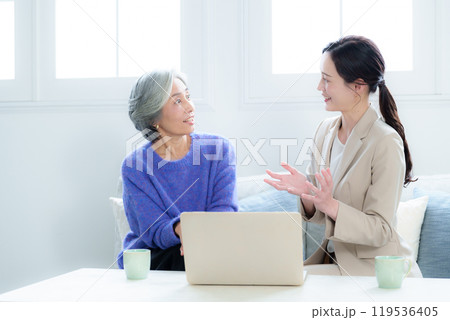 訪問営業の話を聞く中高年の女性 119536405