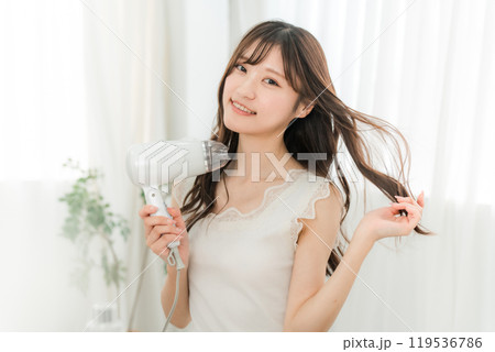 ヘアドライヤーでヘアブロー・髪の毛を乾かす女性（ヘアケア） 119536786