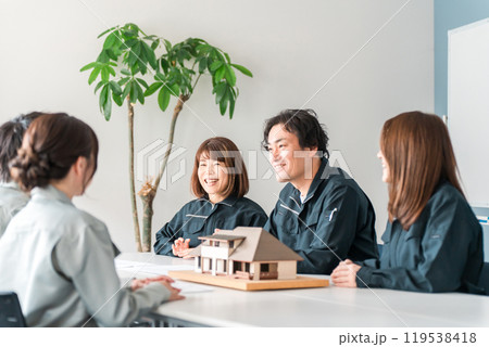 住宅模型を使って商談・説明・プレゼンする作業服姿の建設業・建築業の男女のビジネスマン 住宅模型を使って商談・説明・プレゼンする作業服姿の建設業・建築業の男女のビジネスマン 119538418