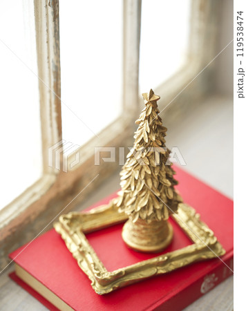 レトロな窓辺に置かれた古い洋書とクリスマスツリー 119538474