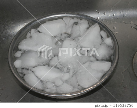 シンクの中のステンレスボールに入っている白濁した氷 119538756