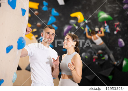 Young man and woman talking near climbing wall Young man and woman talking near climbing wall 119538984
