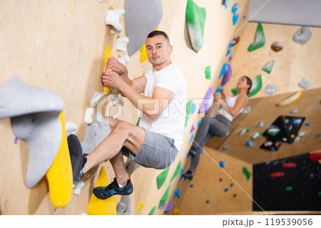 Man climbs steep artificial wall in sports complex and trains endurance 119539056
