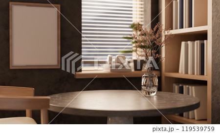 A round dark stone marble table by the window and a bookshelf in a cozy contemporary room. A round dark stone marble table by the window and a bookshelf in a cozy contemporary room. 119539759