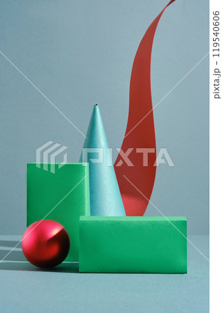 A blue cone, red sphere, and green rectangular prisms with empty space for display products are arranged against a light blue background. A long red ribbon curls around the cone. A blue cone, red sphere, and green rectangular prisms with empty space for display products are arranged against a light blue background. A long red ribbon curls around the cone. 119540606