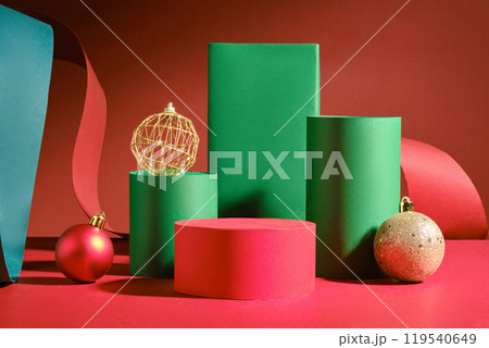 Green rectangles, two green cylinder platforms, Christmas balls, a red paper strip, and a green paper plate surround the vacant red cylinder platform. An example picture of Christmas merchandise. Green rectangles, two green cylinder platforms, Christmas balls, a red paper strip, and a green paper plate surround the vacant red cylinder platform. An example picture of Christmas merchandise. 119540649