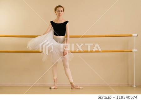Ballet dancer in dance studio demonstrates artistry and grace. 119540674