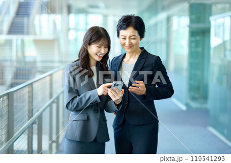 スマホを見るスーツ姿の2人のビジネスウーマン 119541293