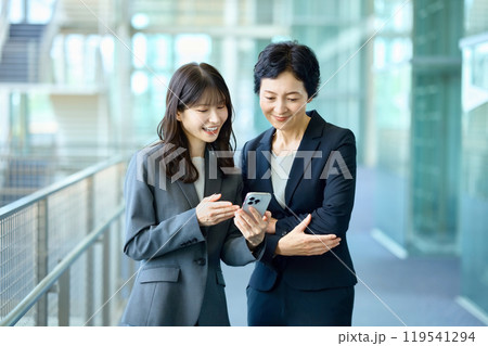 スマホを見るスーツ姿の2人のビジネスウーマン 119541294