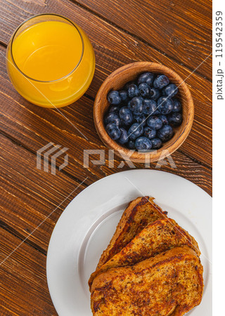 French toast on a white plate with blueberries and orange juice for breakfast 119542359