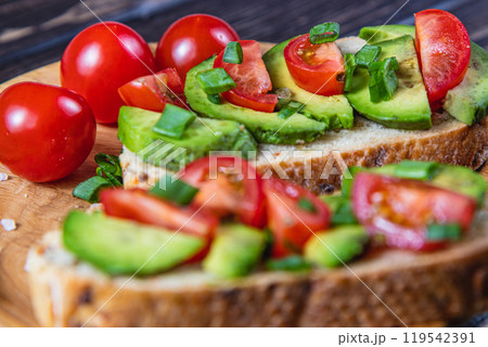 Avocado toast topped with tomato and green onion on a slice of carrot bread Avocado toast topped with tomato and green onion on a slice of carrot bread 119542391
