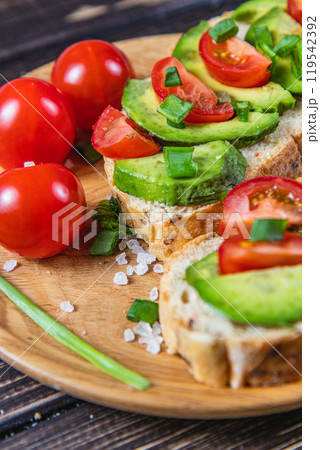 Avocado toast topped with tomato and green onion on a slice of carrot bread 119542392