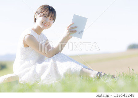 草原で読書をする若い女性 119543249