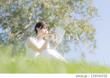 草原で読書をする若い女性 119543250