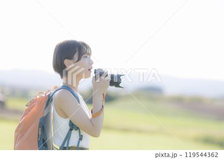 草原でカメラを構える若い女性 草原でカメラを構える若い女性 119544362