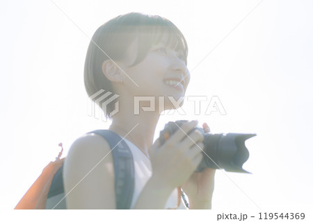 草原でカメラを構える若い女性 119544369