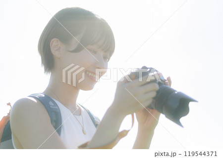 草原でカメラを構える若い女性 119544371