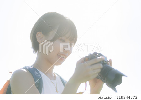 草原でカメラを構える若い女性 草原でカメラを構える若い女性 119544372