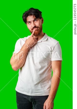A man contemplates thoughtfully against a bright green background 119545773