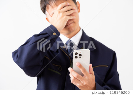 スマホを見ながら悩む作業着姿のミドル男性ビジネスマン スマホを見ながら悩む作業着姿のミドル男性ビジネスマン 119546200