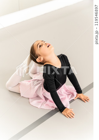 Healthy little girl dancer practicing ballet on floor in gymnastic studio Healthy little girl dancer practicing ballet on floor in gymnastic studio 119546897