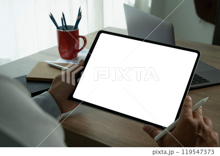 A businessman holds a mockup. iPad digital tablet with blank screen Mockup replaces your design mockup in the office. A businessman holds a mockup. iPad digital tablet with blank screen Mockup replaces your design mockup in the office. 119547373