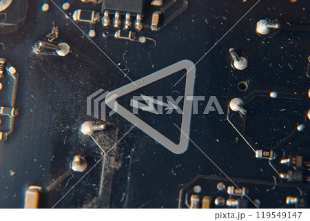 A detailed view showcasing a vibrant circuit board that prominently features a warning symbol indicating electricity 119549147