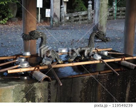 薄日の中の潮江八幡宮の手水舎（天満宮の御水屋の龍神と柄杓） 119549239