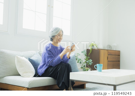 リビングでくつろぐニットのシニア女性　　　 119549243