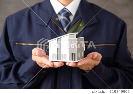住宅模型を持つ作業着を着たミドル男性ビジネスマン 住宅模型を持つ作業着を着たミドル男性ビジネスマン 119549905