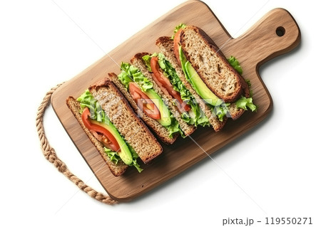 Delicious layered sandwich with fresh vegetables on a wooden cutting board prepared in a bright Delicious layered sandwich with fresh vegetables on a wooden cutting board prepared in a bright 119550271
