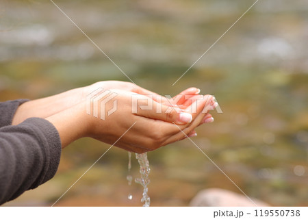 Woman hands catching fresh water from river Woman hands catching fresh water from river 119550738