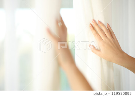 Woman hands opening curtains at home 119550893