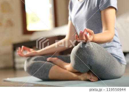 Woman doing yoga exercise on the floor at home 119550944