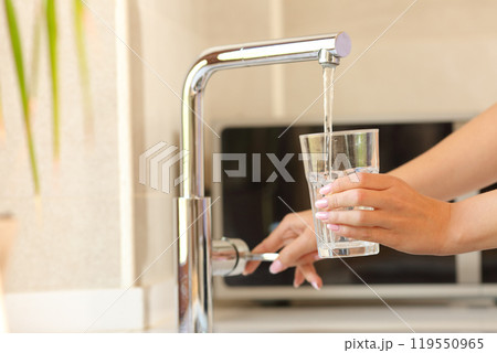Woman hands filling a glass of tap water Woman hands filling a glass of tap water 119550965