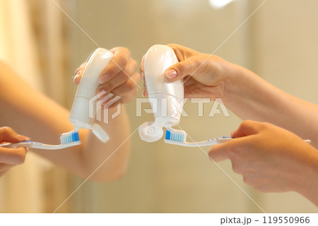 Woman hands putting toothpaste on the brush Woman hands putting toothpaste on the brush 119550966