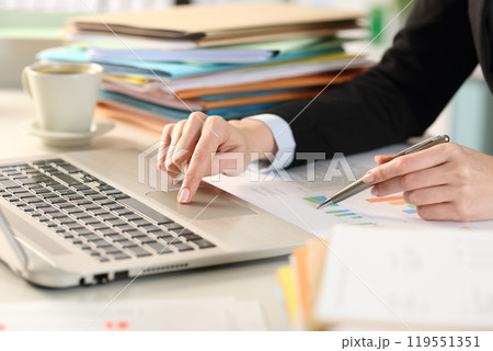 Business woman hand comparing report with laptop Business woman hand comparing report with laptop 119551351