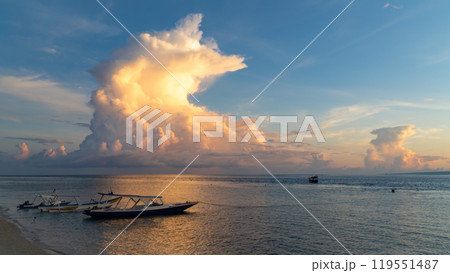 A small boat is gently floating atop a calm body of water A small boat is gently floating atop a calm body of water 119551487
