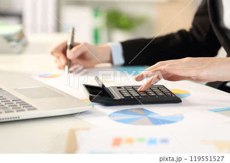 Executive hands calculating with calculator and graphs 119551527