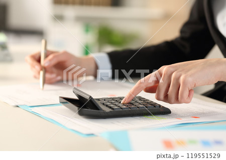 Executive hands calculating with calculator at the office 119551529