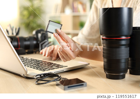 Photographer hands showing card using laptop 119551617