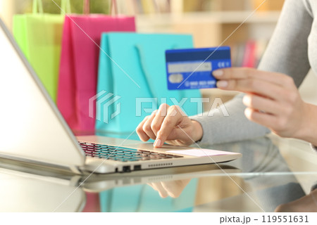 Shopper hands buying with credit card on laptop 119551631