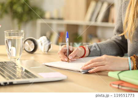 Student hands writing on notebook doing homework Student hands writing on notebook doing homework 119551773