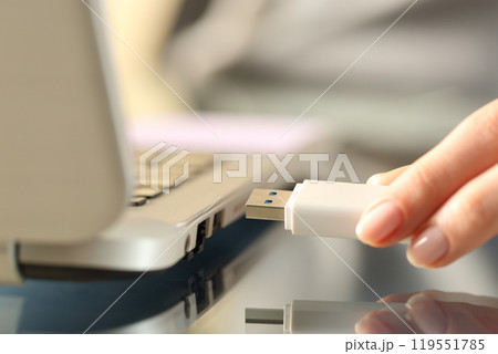 Woman connecting usb flash drive on a laptop Woman connecting usb flash drive on a laptop 119551785