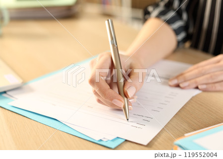 Woman hands filling out application form at home 119552004